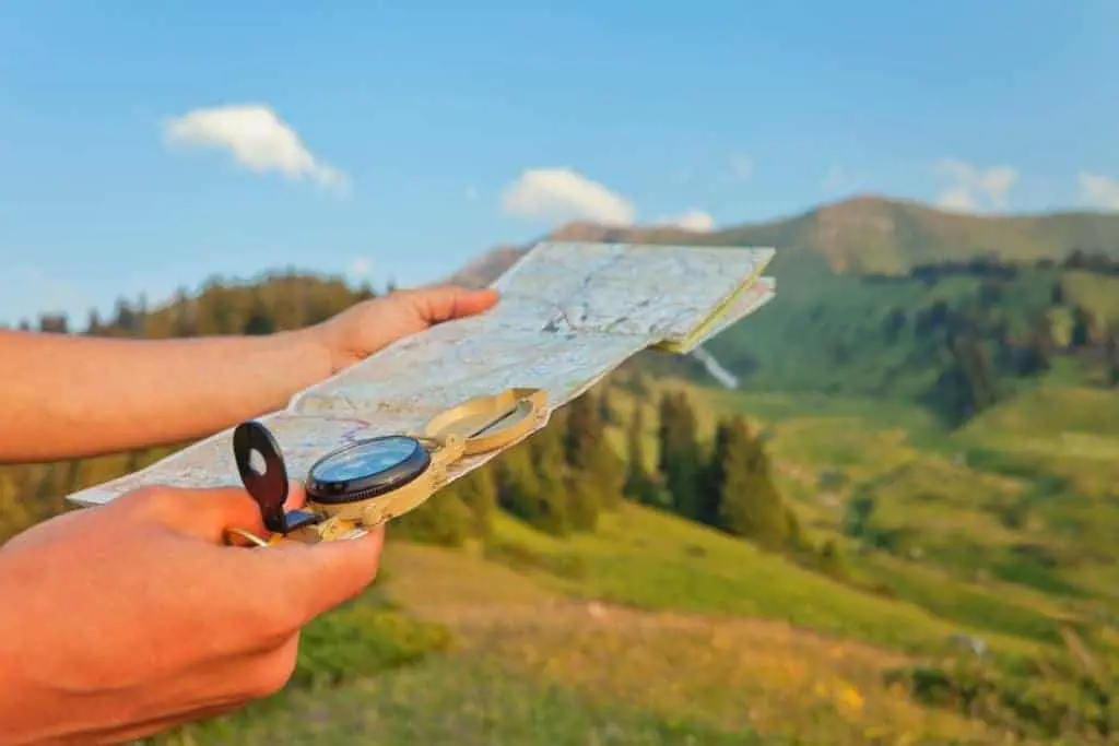 Man consulting a map and compass in the wilderness