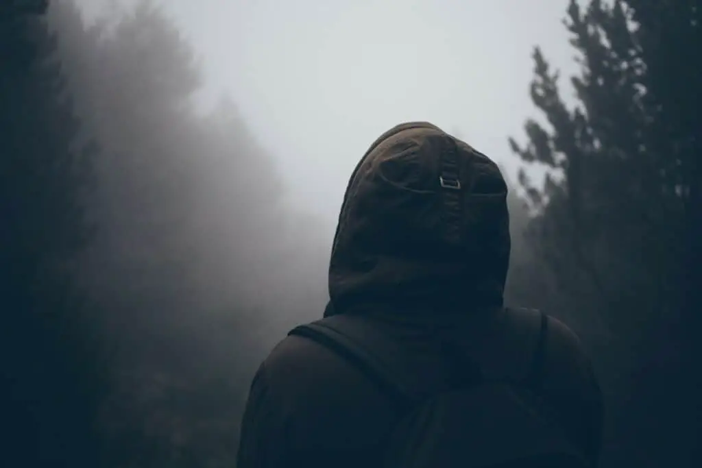Gray man wearing a stealth backpack in a foggy environment.